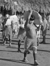 Figure 32. Children (ta’rebzu) carrying ceremonial maize loaves across the community plaza after being ritually painted by their ceremonial father (danhorebzu’wa), 2005.